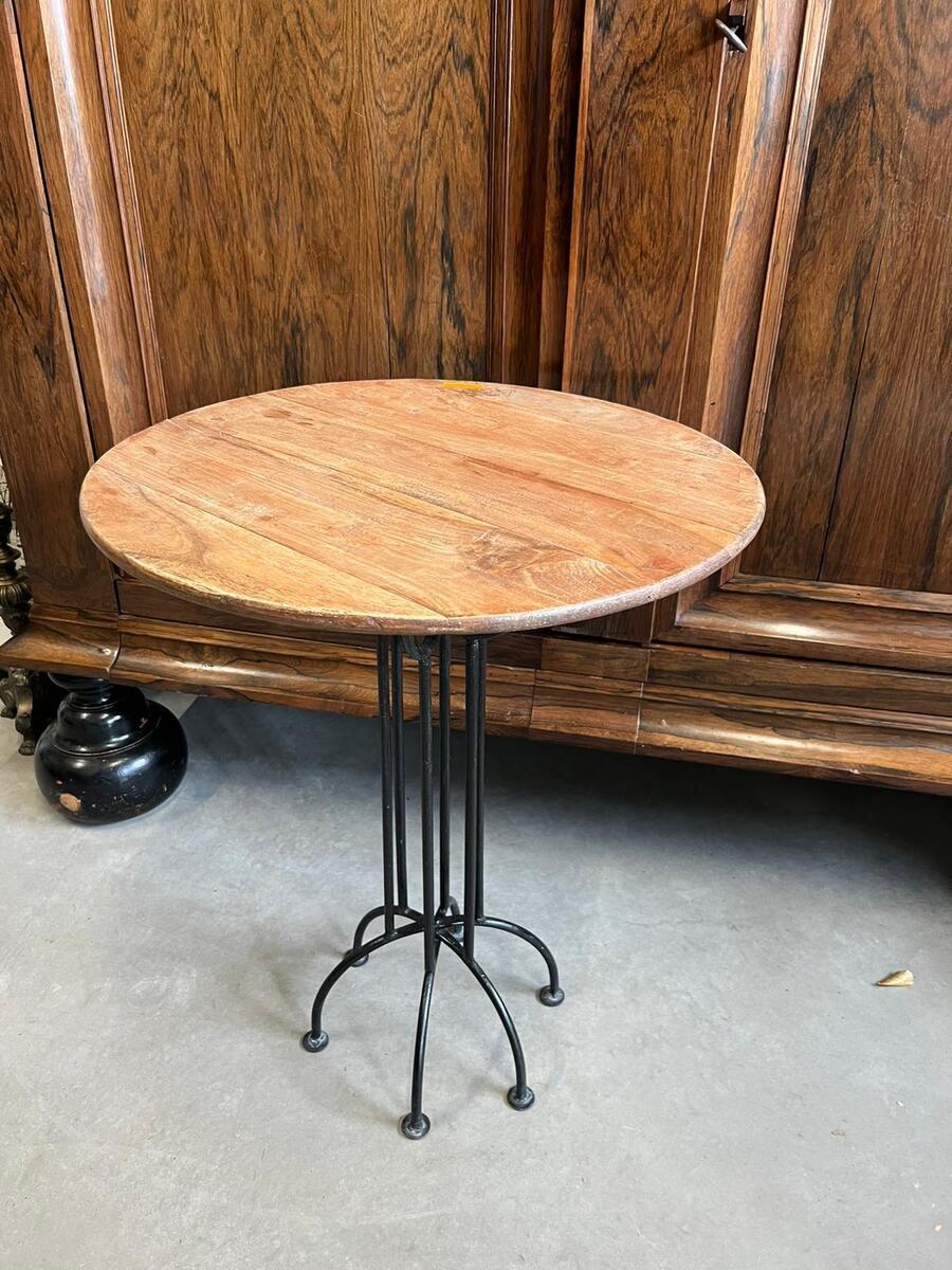 Industrieel ronde tafel met een houten blad en smeedijzeren onderstel 